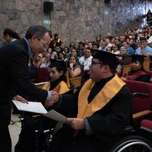 Egresado con discapacidad recibiendo su reconocimiento 