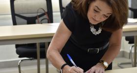 Egresada firmando acta de titulación